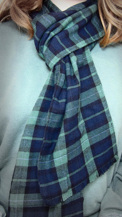 Model wearing black watch tartan flannel scarf made of 100% cotton. Soft, warm cotton fleece. Handmade in Washington State, USA